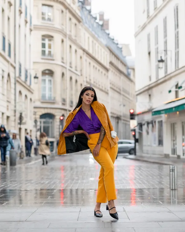 Woman in a mustard outfit crossing a city street