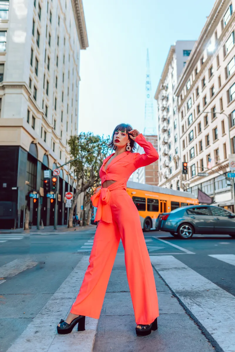 Woman in a red tailored outfit walking outdoors