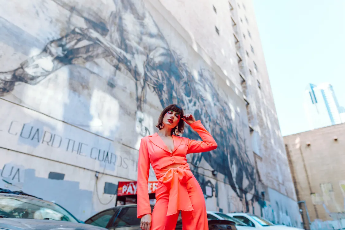 Woman wearing an orange statement coat in the city